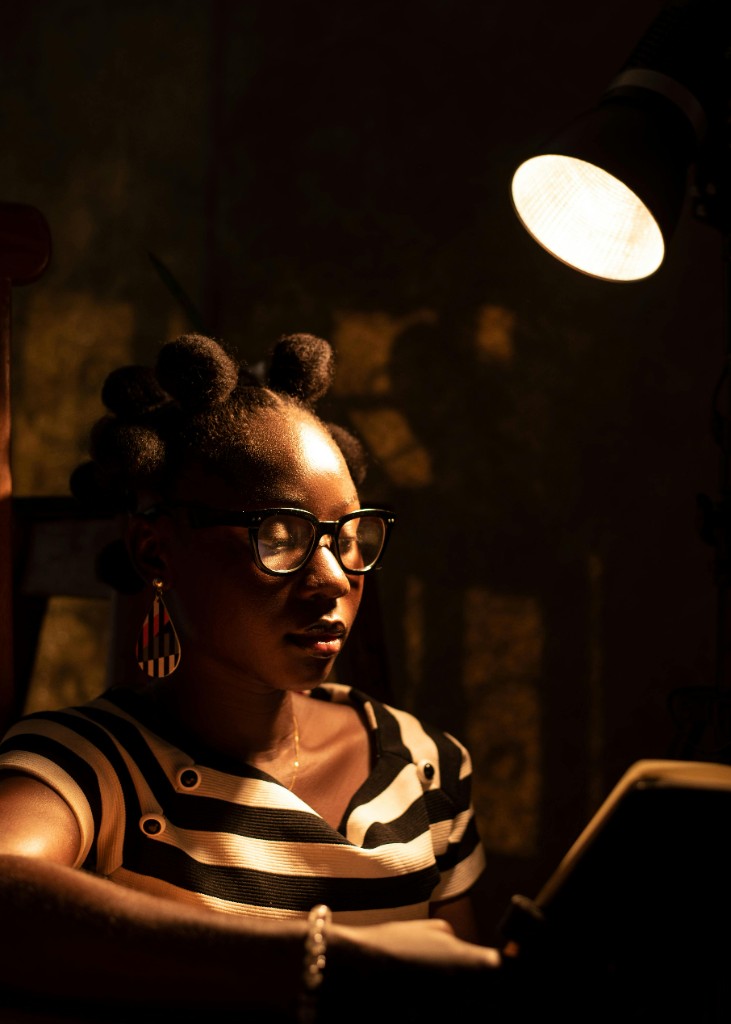 Jeune femme africaine en lecture, lumière chaude de lampe